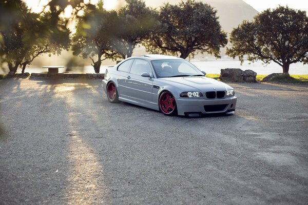 White BMW e46 with red discs on a background of trees