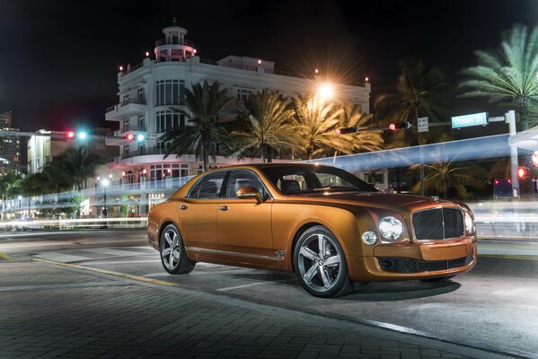 Bentley de color naranja en medio de la ciudad nocturna