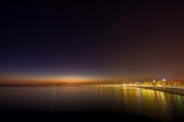 Superficie a specchio dell oceano sotto il cielo notturno nero