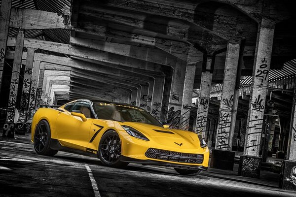 Żółty Chevrolet Corvette na tle kolumn