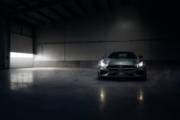 Silver mercedes-Benz amg gt in a hangar in the fog