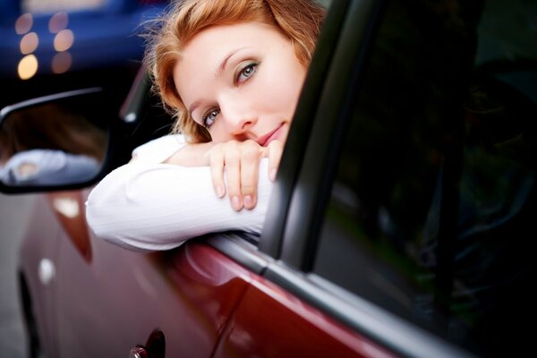 La chica en el coche. Coche rojo. El coche y la chica. La chica te Mira desde el coche