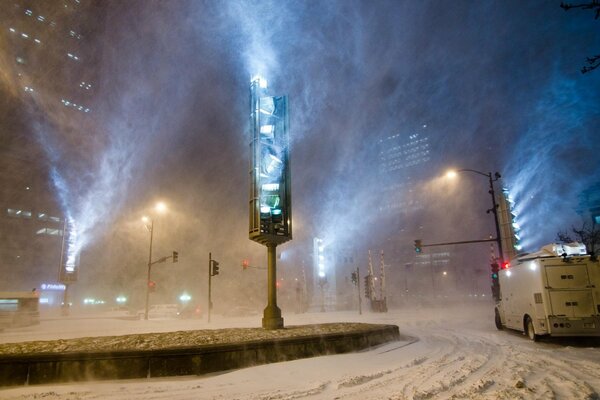 A night city in the snow at a traffic light