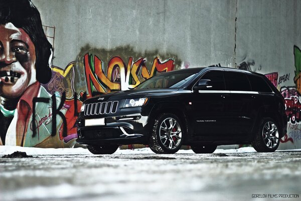 Schwarzer grand cherokee Jeep und Graffiti an der Wand