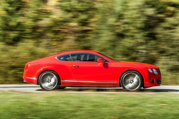 Bentley rojo sobre fondo borroso en movimiento