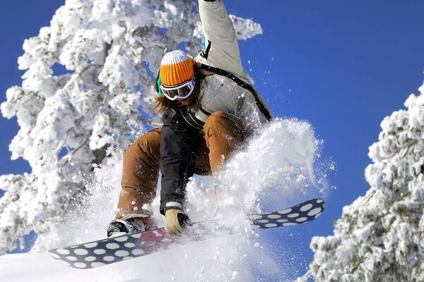 Winterflug eines Mädchens auf einem Snowboard