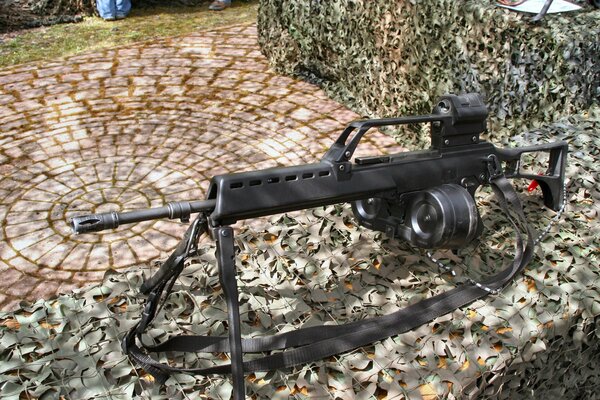 A hand-held machine gun on a camouflage net