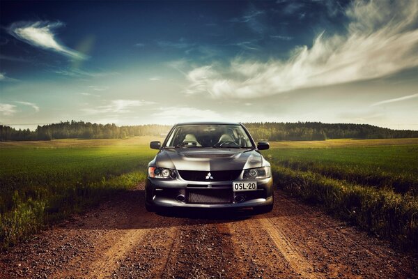 Auto Mitsubishi auf dem Boden vor dem Hintergrund der Wolken