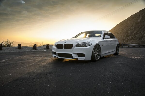 Coche blanco marca BMW al atardecer