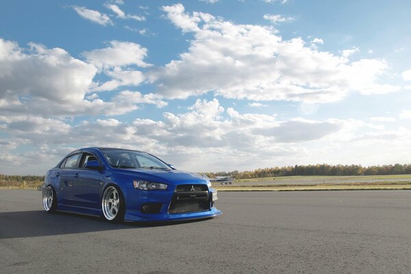 Blue mitsubishi evolution slides on the road