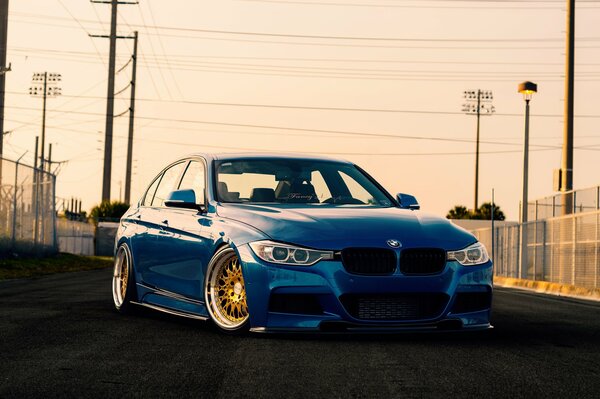 Blue sedan over street wires