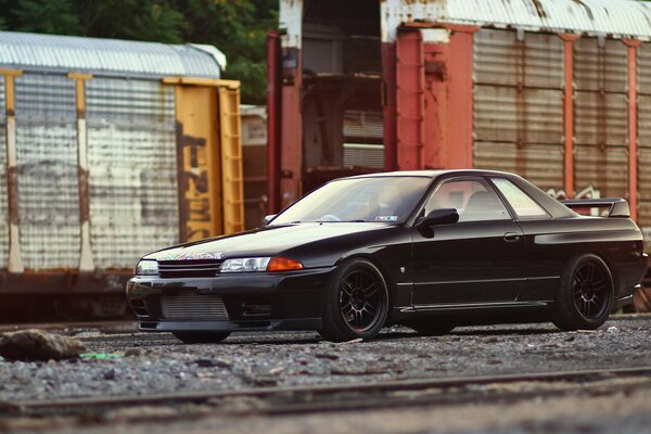 Black nissan in an industrial area