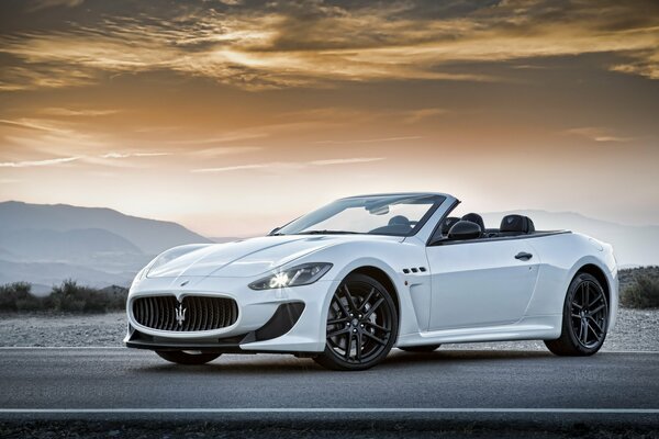 A convertible car on the background of a hilly landscape