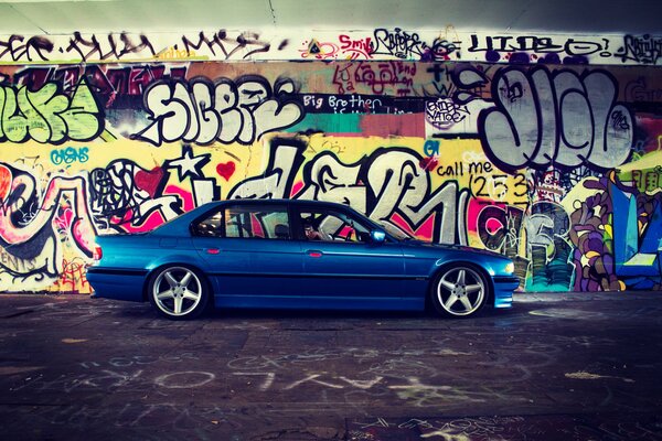 Blue BMW on a background of bright graffiti