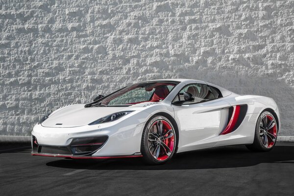 McLaren sportcar blanc sur fond de mur de pierre blanche