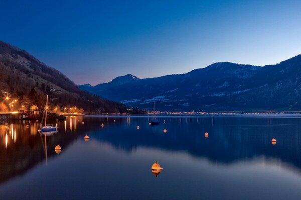 Night sky, mountains, shore with lights