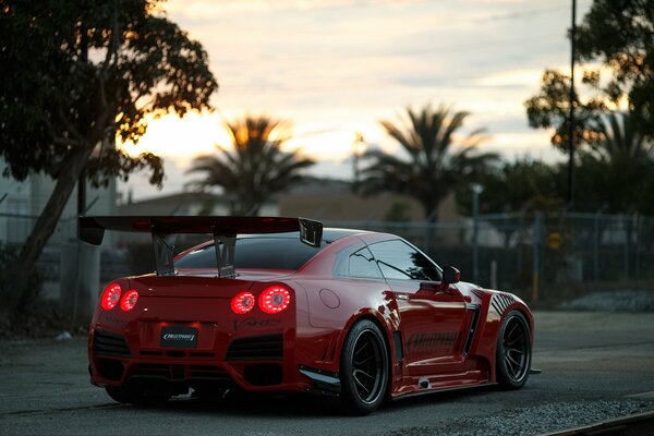 Kirschfarbener Nissan mit Spoiler in Bewegung