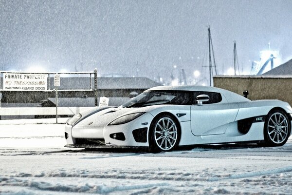 Auto im Winter. Weißes Auto auf Schnee Hintergrund. Supersportwagen. Cooles Auto. Königsegg