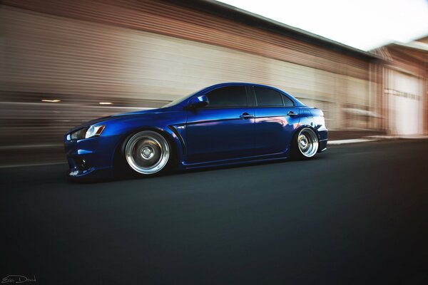 The concept of the bright blue mitsubishi evo x in motion