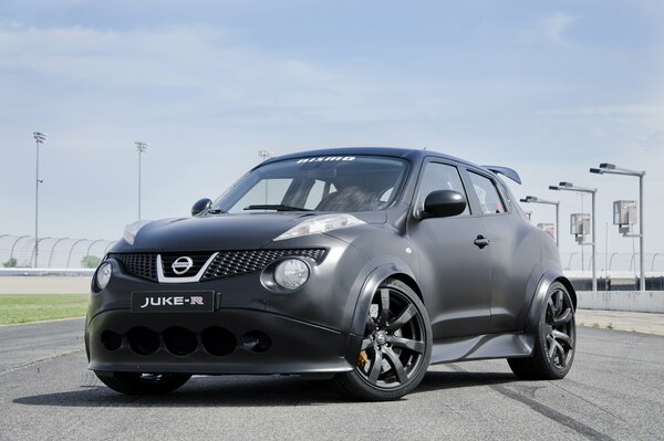 A black Nissan beetle stands on the asphalt