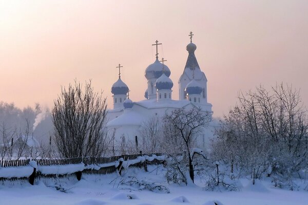 Iglesia de invierno en la bruma de la mañana