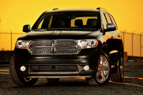 Dodge SUV front view, powerful, on sunset background