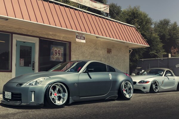 Nissan and BMW in front of the store building