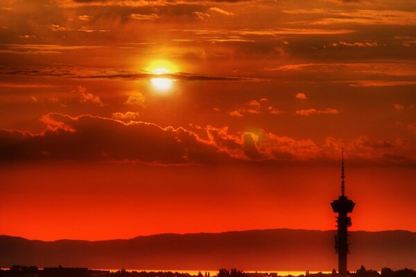 Red sunrise on the background of an old tower