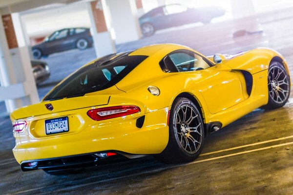 Voiture de sport jaune dans un parking souterrain