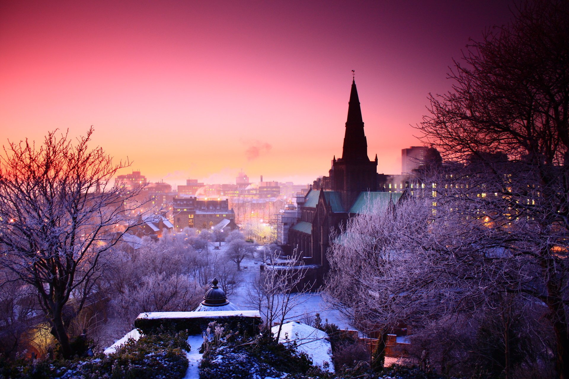 the city winter sunset pink sky frost dome the roofs of the houses snow-covered city trees the sky the night sky the lights of the city