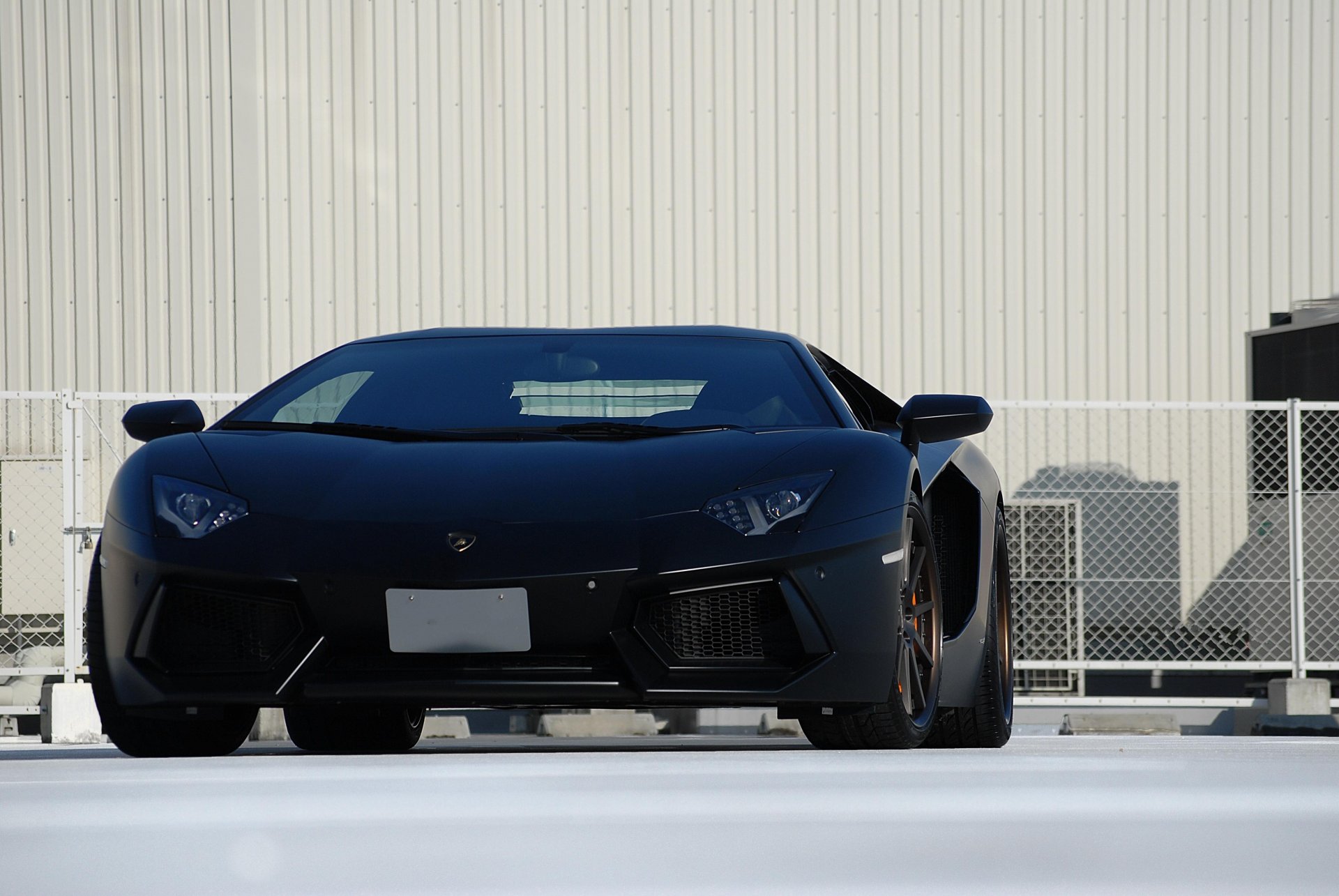 lamborghini aventador lp700-4 black matteamborgini aventador matte black front white wall fence