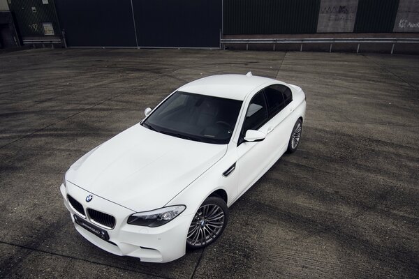 A white bmw car is standing on the site