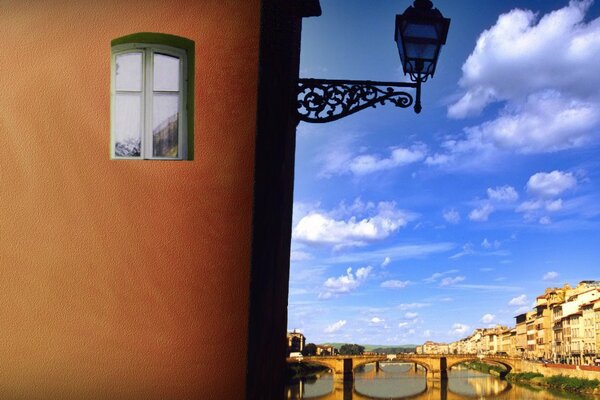 Lanterna sul muro della casa sullo sfondo di un antico ponte