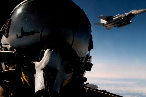 A fighter jet is reflected in the pilot s helmet