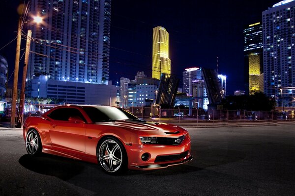 Chevrolet camaro rouge sur fond de ville de nuit