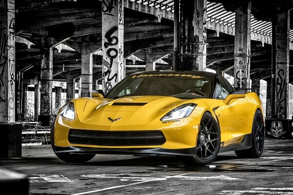 A yellow Chevrolet stands on a black and white background