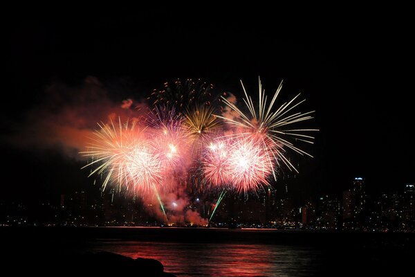 Reflejo de fuegos artificiales en el agua por la noche