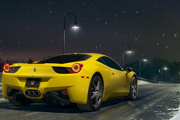 Elegante Ferrari amarillo contra el cielo nevado de la noche