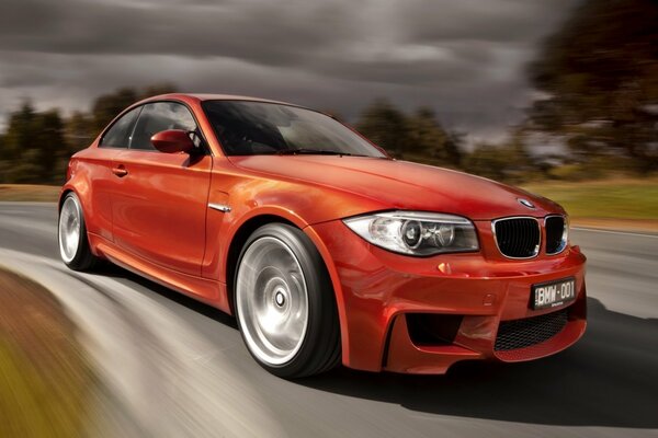 Hermoso coche rojo BMW en el tráfico en la carretera