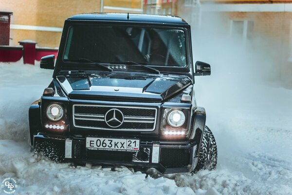 Mercedes noire sur une route enneigée