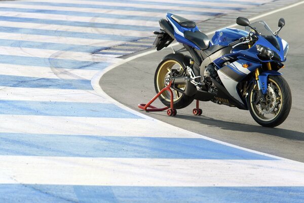 A blue motorcycle is on the track