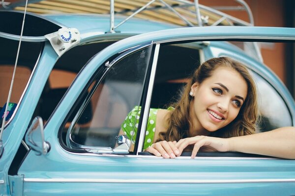 Modelo de chica joven conduciendo un coche retro