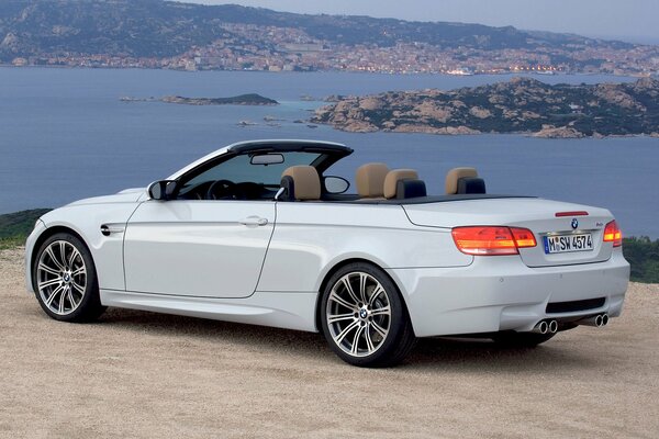 Bianco convertibile BMW M3. bella vista sulla città serale e sul mare