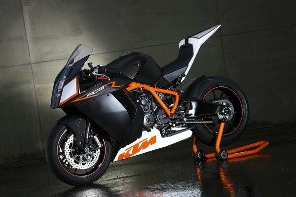 Мотобайк KTM rc8 2009 года стоит на фоне бетонной стены