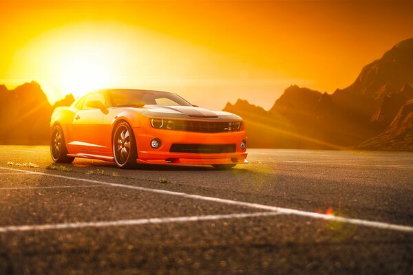 Naranja Camaro SS en el fondo de las montañas y el sol