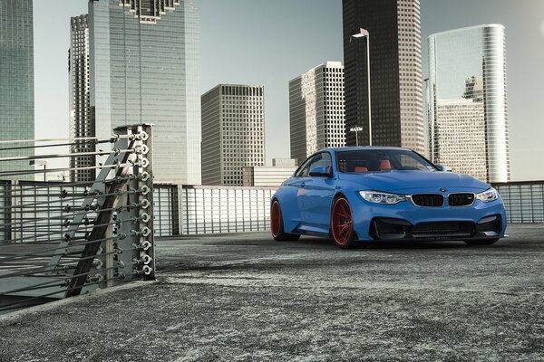 Blue BMW vorsteiner on the background of a modern metropolis