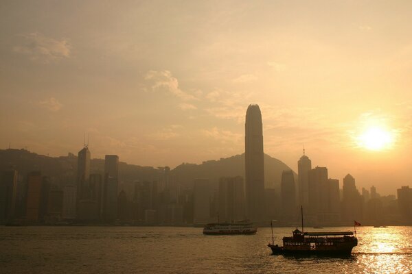 View of the city in the rays of the setting sun on the background of the bay