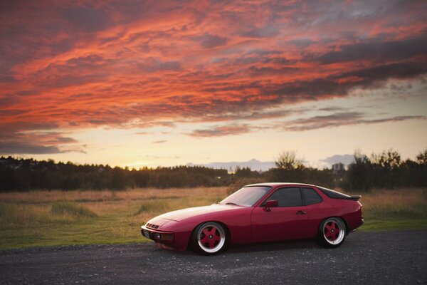 Porsche rojo en el fondo de una puesta de sol roja