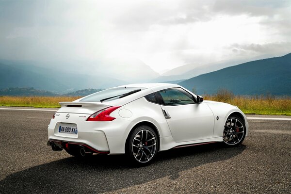 Weißer Nissan im Hintergrund einer Berglandschaft