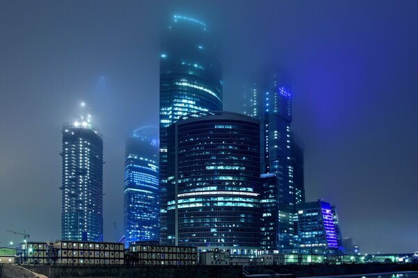 Gratte-ciel de nuit de Moscou brûlant des lumières dans le brouillard